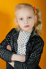 Close up portrait of a girl, she has folded her hands and looks to the side. Smile and joy on the face, wearing a hat
