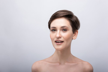 Portrait of a young girl with a long neck, almost no makeup on her face, photo without retouching, natural makeup and vivid emotions, smile and joy in the look