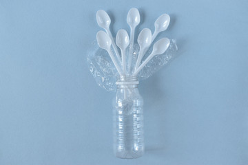 Plastic utensils on a blue background with a copy space.