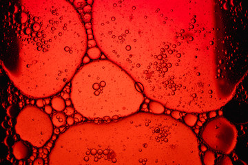 Oil on the surface of the water Soap foam with bubbles, red