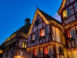 fachada de madera entramada con decoración de luces y guirnaldas de navidad al aterdecer