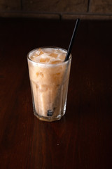 Banana cocktail with ice on wooden background