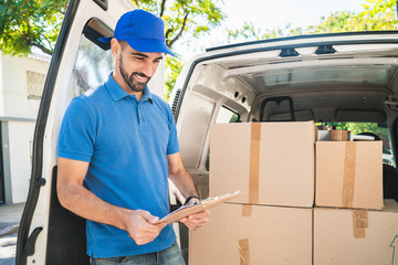 Delivery man checking the products with checklist.