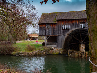 molino de madera junto a orilla de río con rueda de aspas en campo de otoño © Javier Cordero