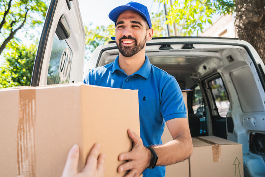 Delivery Man Carrying Packages While Making Home Delivery.