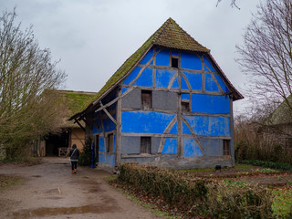 granja de fachada de color azul intenso u entramado de madera con cielo nublado