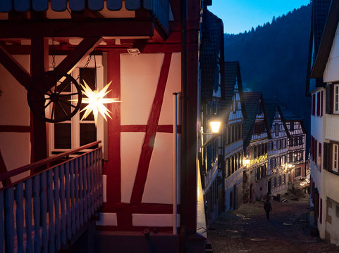 estrella iluminada de navidad en calle nocturna medieval al anochecer