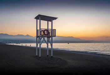 puesto de socorro de madera en playa desierta al amanecer