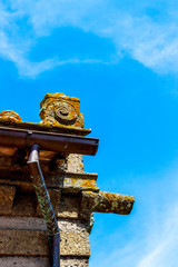Fototapeta na wymiar Palazzo Orsini or Orsini Palace high section architectural detail against the sunny summer sky in the historic district of Bomarzo, Province of Viterbo, Lazio, Italy