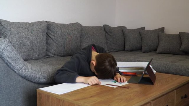 Slow motion footage. Sad tired frustrated boy with many books and holding paper with word Help. Education concept. Learning difficulties.