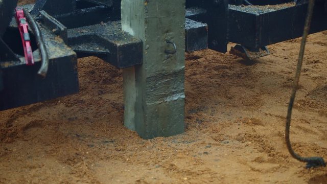 Concrete pile hammer ram in the sand the ground by using the machine. Clouse up