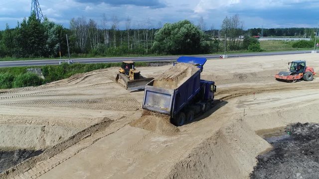 Truck pours sand. Construction transport road. Development highway. Equipment.