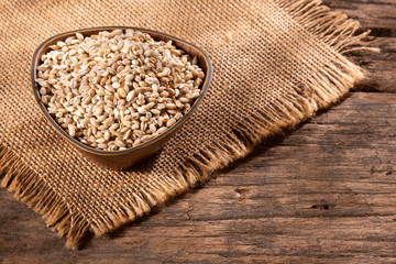 Dried pearl barley in a wooden bowl - Hordeum vulgare