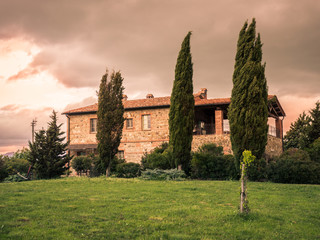 Typical Tuscan farmhouse surrounded by cypress trees.