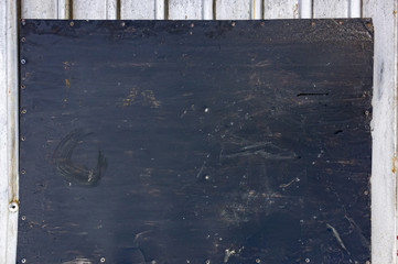 a sheet of black iron with traces of dirt lies on a white profile