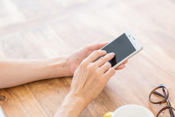 部屋でスマホを見るシニア女性　手元　ボディパーツ