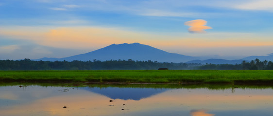 Fototapeta na wymiar sunset over the lake blue mountain and ricefield