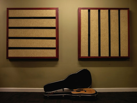 Acoustic Guitar On Floor Against Wall