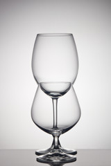 Empty glasses for wine and cognac on gray background. Glassware