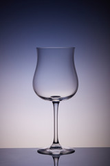 Empty glass for wine on multicolor gradient background. Wineglass