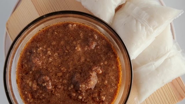 Flatlay rotating footage of "kuah kacang" or peanut sauce with "nasi impit". A malay traditional usually serve during Eidul Fitr.
