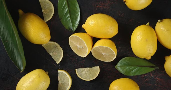 Pieces of fresh lemon with leaves slowly rotate.