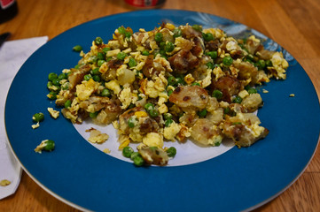 Vegetarian Scrambled Eggs with Peas and Corn and Potatoes Fried in a Hash