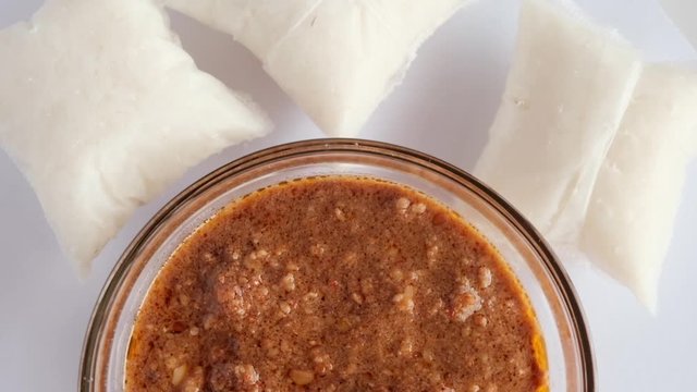 Flatlay rotating footage of "kuah kacang" or peanut sauce with "nasi impit". A malay traditional usually serve during Eidul Fitr.