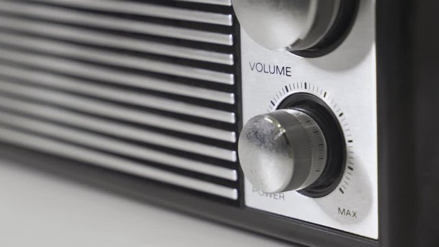 Close up - hand turns volume knob dial - old transistor radio fm am retro device