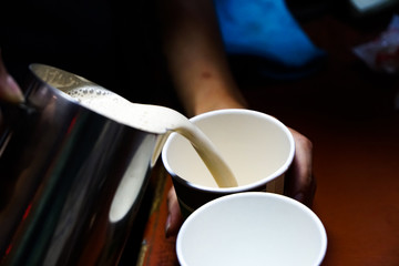 cappuccino with froth poured from a coffee pot into a mug
