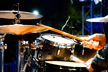 Fototapeta na wymiar drum set on stage, close-up of the hands of a drummer performing music 