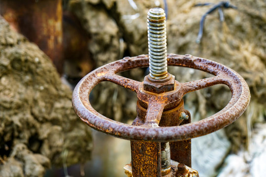 old rusty big valve on a pipe, brown
