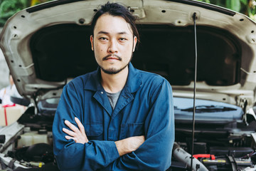 Mechanic Automobile Technician and Jobs Occupation Concept, Portrait Confident Man Technician Vehicle  Automotive Standing Arm Crossed in front of Car Workshop. Mechanical Maintenance