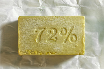 Natural hygienic  soap lies on white wrapping paper.