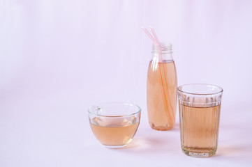Glassware with Apple juice on a pink background