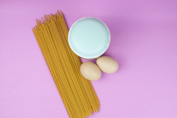 Food stock for quarantine isolation period on purple background. Rice, egg, spaghetti. Food delivery, Donation. Copyspace