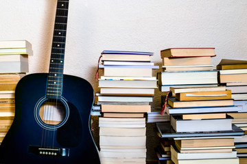 blue electro-acoustic guitar and piles of books