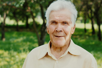 Portrait of happy old senior man with gray hair looking with smile at camera.