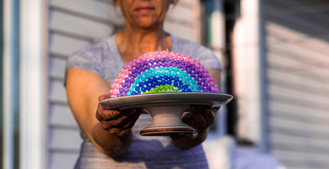 Woman holding rainbow cake during Covid-19 quarantine at home. Stay at home Social media campaign...