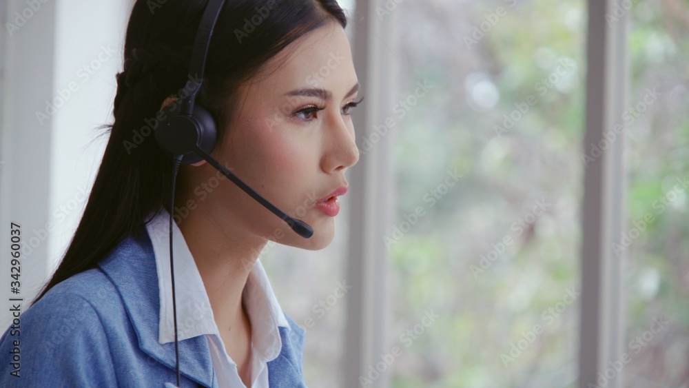 Poster customer support agent or call center with headset works on desktop computer while supporting the cu