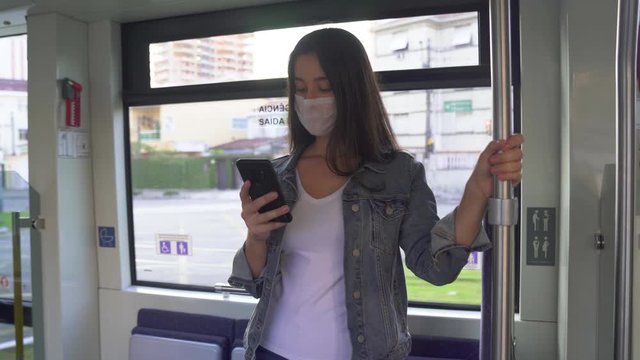 Young woman in protective medical face mask in a subway car, pandemic coronavirus concept
