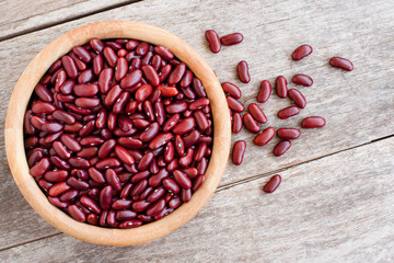 Closeup red bean or kidney beans in wooden bowl isolated onwood table background. Top view. Flat lay.