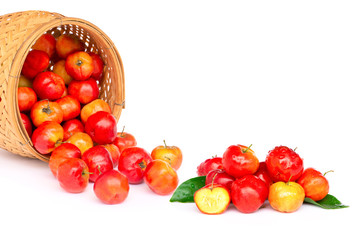 Closeup fresh small red organic  acerola cherry fruits (Malpighia Glabra) with green leaf in wooden bowl isolated on white background. Top view. Flat lay.