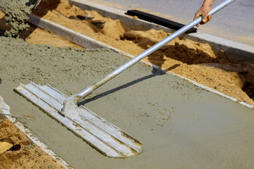 Float being used to smooth wet concrete