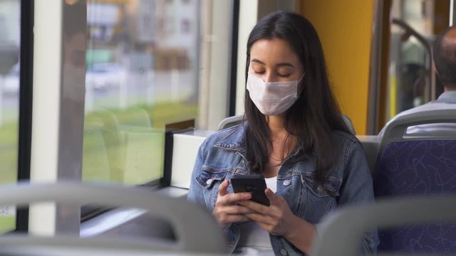 Young woman in protective medical face mask in a subway car, pandemic coronavirus concept
