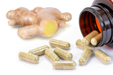 Fresh ginger root with capsules in brown glass bottle isolated on white background. Herbal medicine...