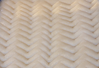 Cheese halva is uncooked white with zigzag lines on it. It is made from cheese and semolina.