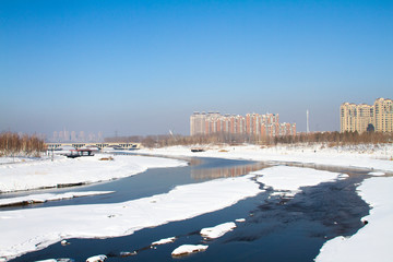 Frozen river covered by snow landscape in a city 