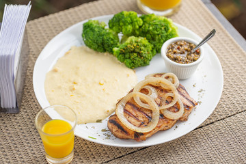 Typically Brazilian food with broccoli, corn cream and chicken steak