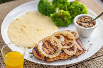 Typically Brazilian food with broccoli, corn cream and chicken steak